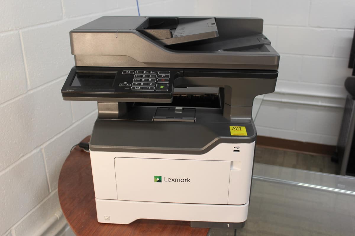 A Lexmark multifunction printer on a table in an office setting.