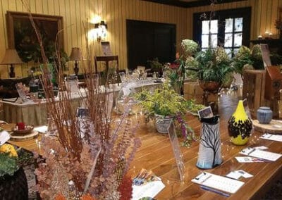 A table displaying various plants, vases, and decorative items in a cozy room.