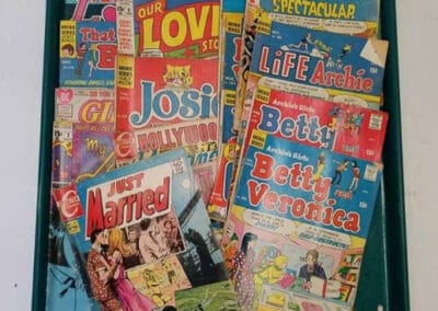 A tray filled with assorted vintage comic books, including titles like "Josie", "Life with Betty", and "Christmas Spectacular".