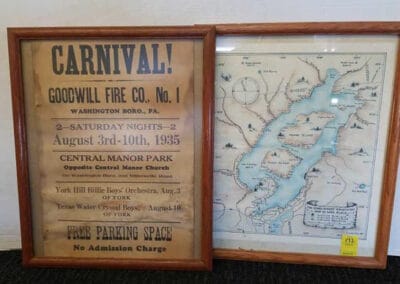 Two framed vintage items: left, 1925 carnival poster by Goodwill Fire Co.; right, an old map of a river and surrounding areas.