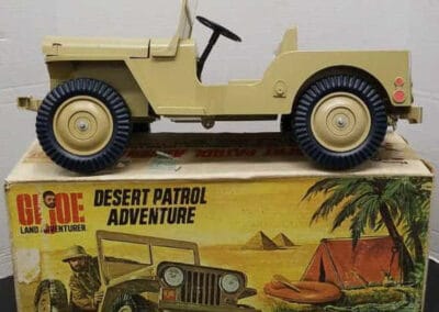 A vintage G.I. Joe Desert Patrol Adventure toy Jeep displayed on top of its original illustrated packaging.