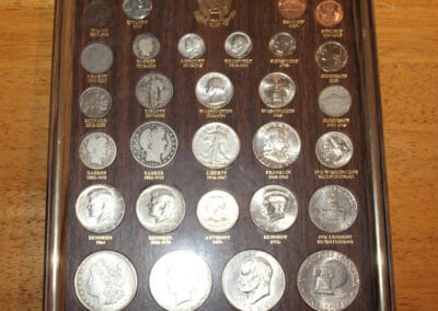 Display of U.S. twentieth century type coins in a wooden frame, including various denominations and designs.