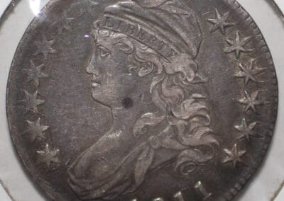 Close-up of an 1811 U.S. silver coin featuring the profile of Lady Liberty wearing a cap, surrounded by stars.