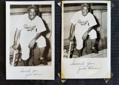 Two vintage photos of Jackie Robinson in a Dodgers uniform, sitting in a dugout, each photo autographed at the bottom.