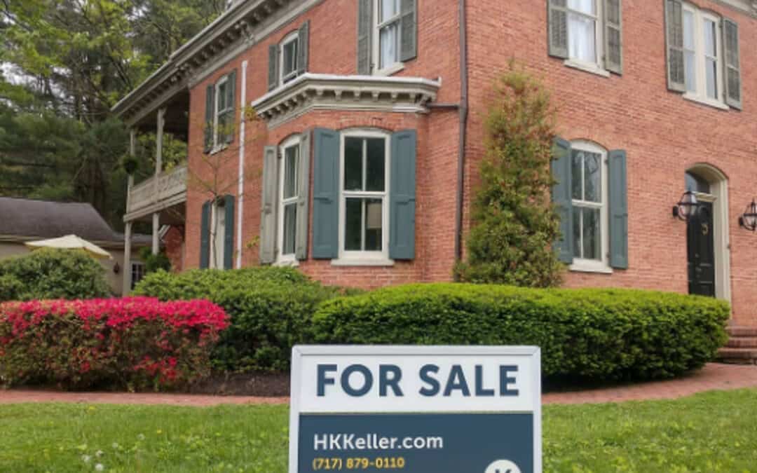 A two-story brick house with white trim and a "for sale" sign from H. K.. Keller in the front yard.